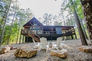 Broken Bow Cabins Texas Time exterior and firepit with Adirondack chairs